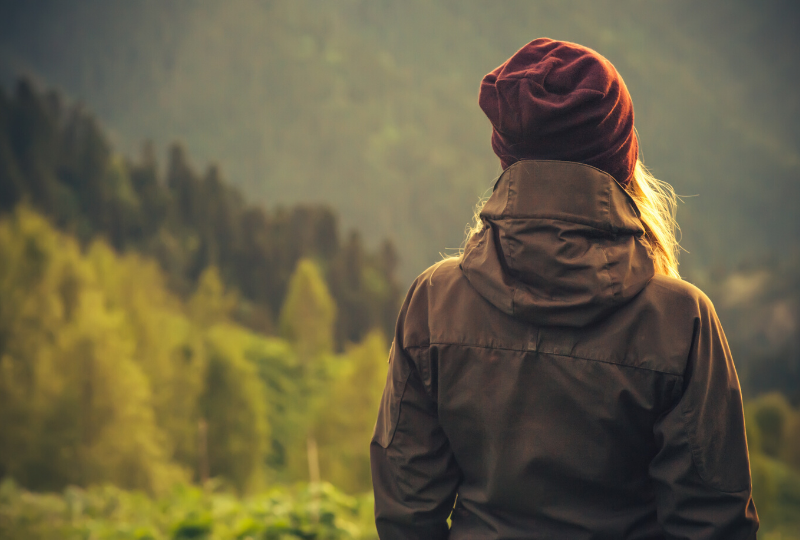 A woman standing alone in nature representing an HSP - a highly sensitive person